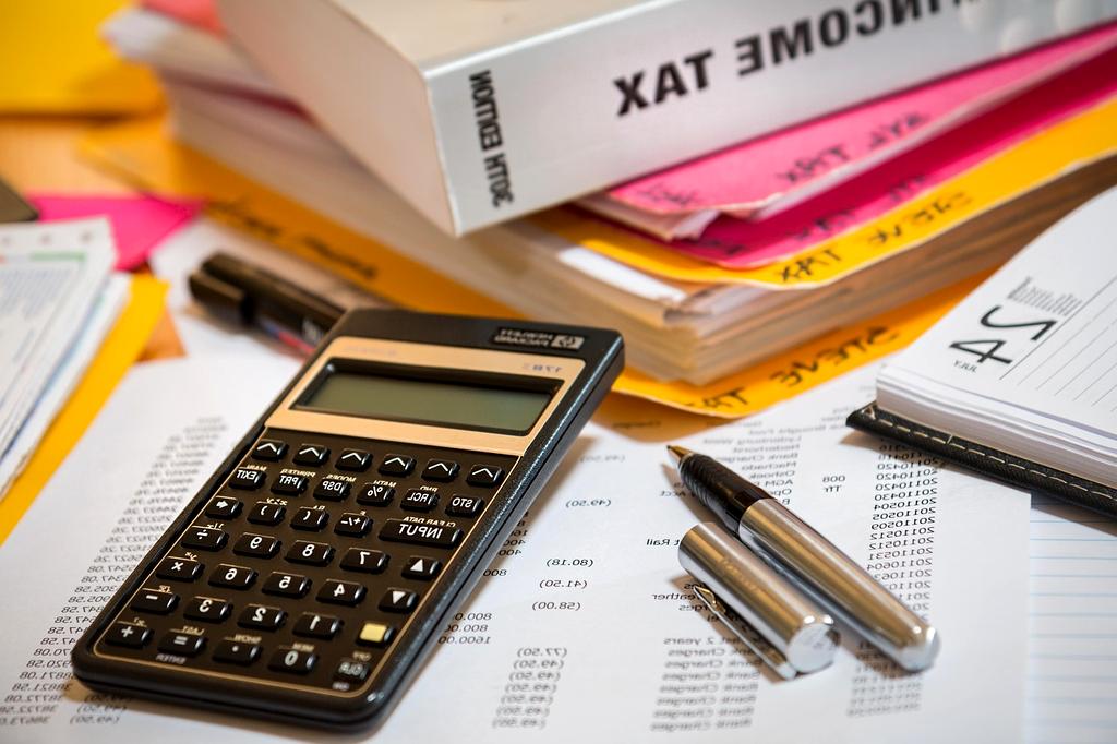Kalkulator i dokumenty finansowe na biurku podczas planowania podatkowego